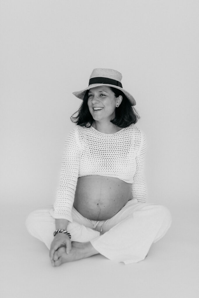 Ehepaar steht auf einer hohen Wiese und freut sich über Babybauch beim Fotoshooting in Alsfeld