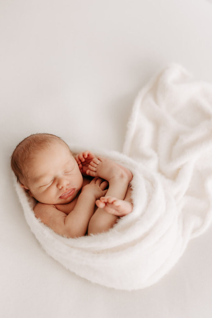 Baby liegt eingewickelt in Decke beim Fotoshooting in Alsfeld